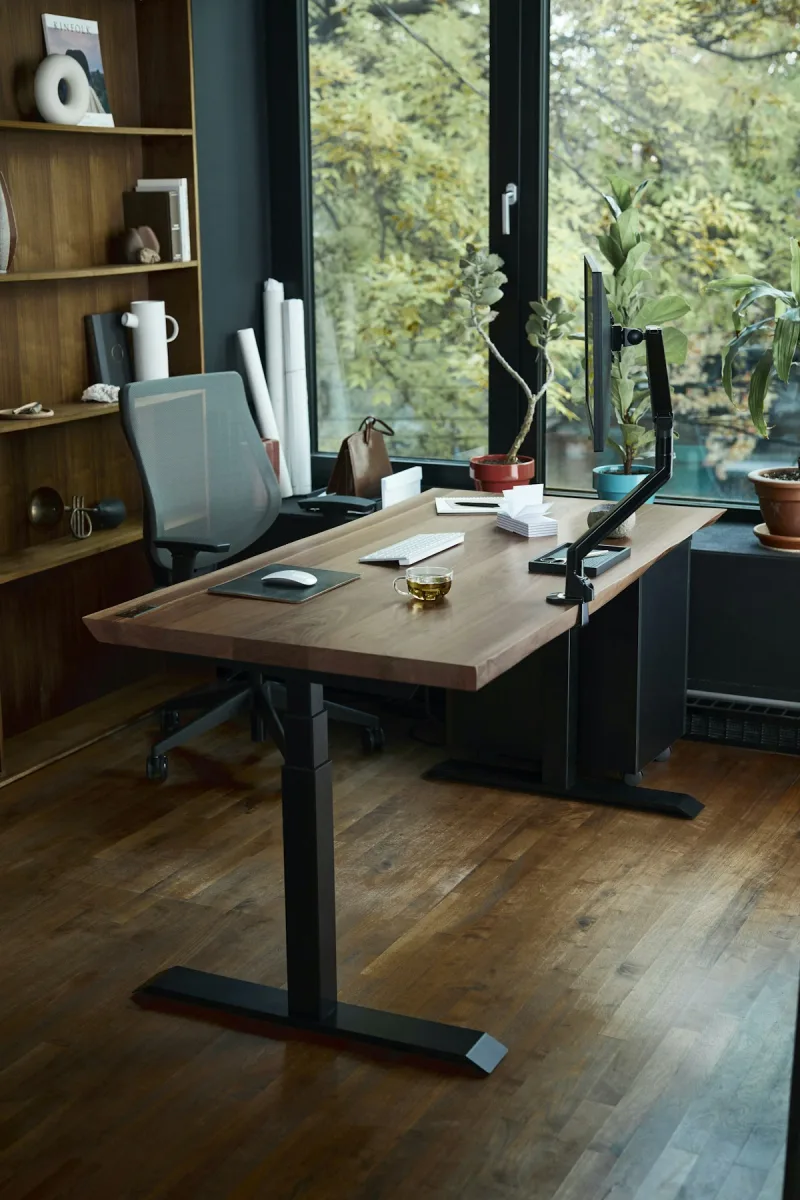 Höhenverstellbarer Schreibtisch mit Stuhl in einem hellen Arbeitszimmer
